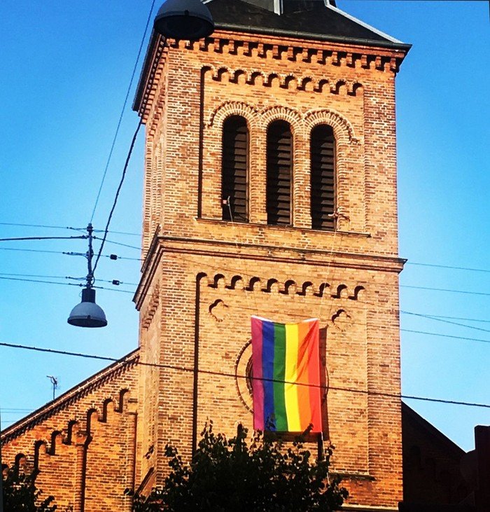 Kirketårn med regnbue flag
